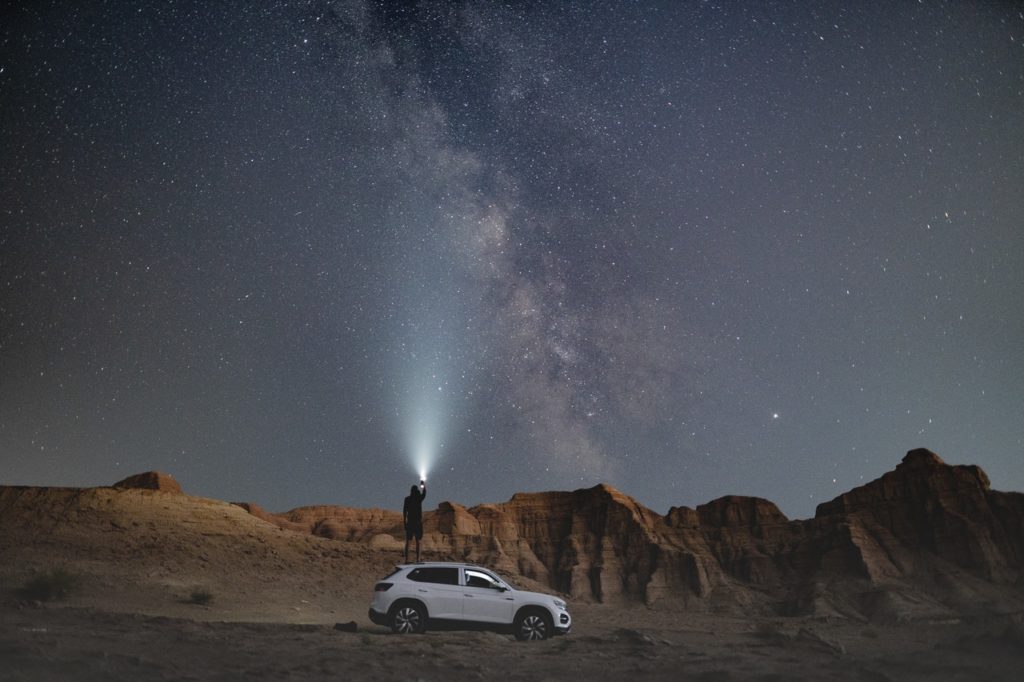 an SUV going under the milky way